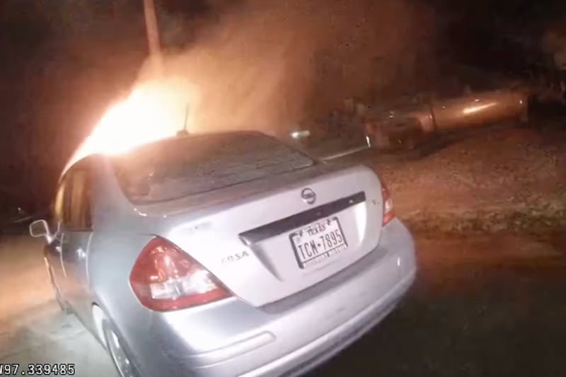 Police smash their way into burning car and drag out driver