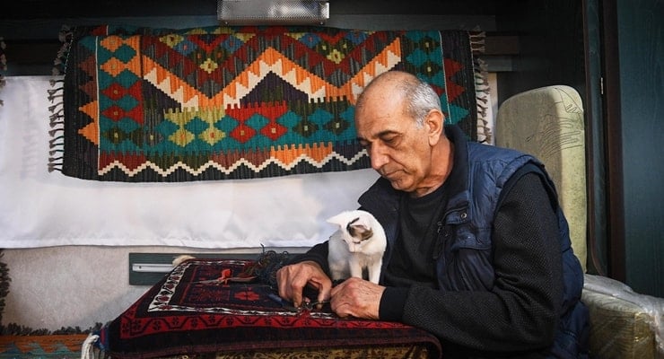 Balıkesir'de halı tamircisi depremler nedeniyle kedisiyle karavanda çalışıyor