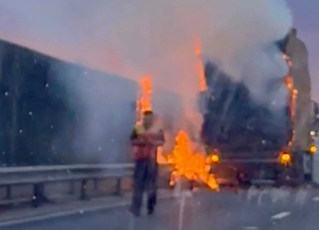 Moment lorry driver calmly walks away from huge hay bale fire on M4